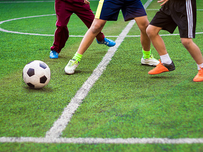 足球运动员在小学体育比赛中竞相参赛玩家男生乐趣场地孩子跑步游戏法庭绿色活动背景图片