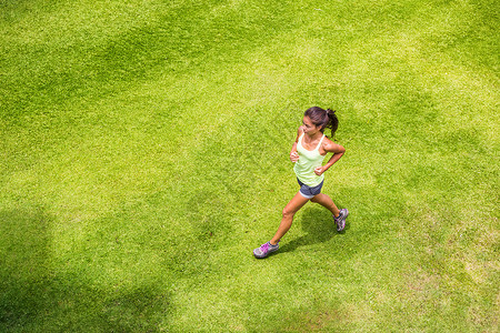活跃的女运动员在野外草地上跑步 参加马拉松运动比赛 亚洲中国体育女孩晨跑户外高清图片素材