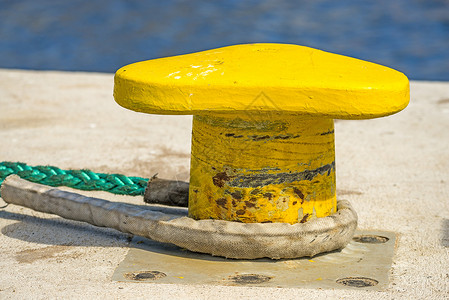 带锚系线的柱状体船运港口海洋安全航海绳索圆圈渔船码头黄色背景图片