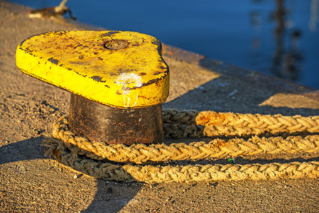 带锚系线的柱状体阴影晴天安全海洋船运绳索黄色圆圈码头港口背景图片