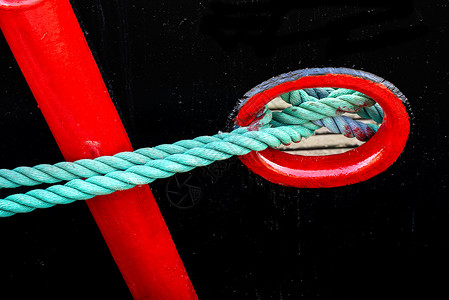 拖拖网渔船的锚泊线绿色锚链码头海洋黑色安全港口刀具船运红色背景图片
