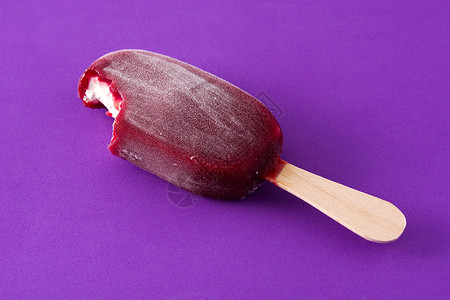 紫罗兰背景的草莓冰棒冰淇淋水果甜点小吃食物白色奶油棒冰红色巧克力背景图片