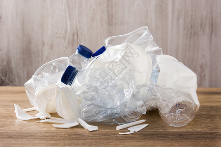 木制背景上可处置的废塑料团体陶器生态回收餐具用具厨具勺子白色环境背景图片