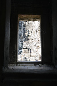 透过废墟窗口看到的石面雕塑巨像头像视觉摄影时期寺庙窗户艺术风格艺术品背景图片