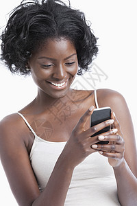 快乐的非洲裔年轻美国女性在白色背景下发来短信技术爆炸手机电话城市细胞女士成人女孩微笑阅读高清图片素材