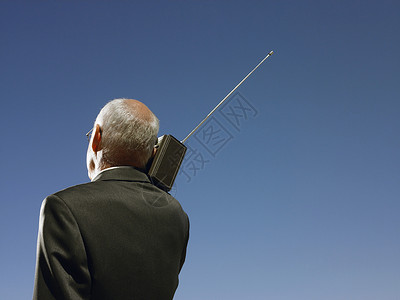 拥有肩头和肩后视角的无线电机的商务人士听力男士男人一人蓝天幸福秃顶享受肩膀天空背景图片