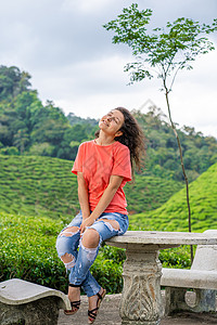 美丽的黑褐色女孩在茶谷中间摆着b热带太阳爬坡场景环境植物阳台土地衬套风景背景图片
