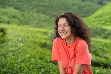 美丽的黑褐色女孩在茶谷中间摆着b爬坡风景收成高地场地场景旅行农村农业女士背景图片