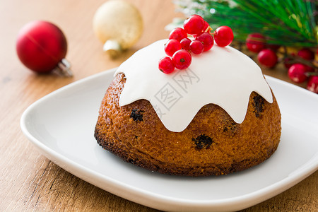 木制桌上的圣诞布丁季节性庆典水果红色蛋糕食物木头甜点坚果背景图片