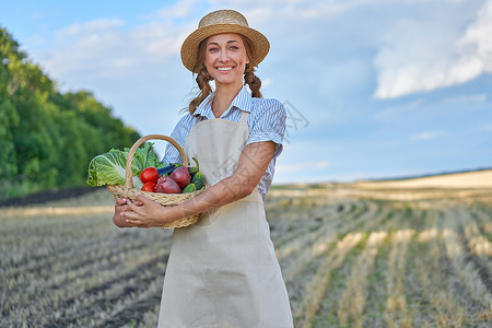 女农民草帽围裙站在农田微笑女农学家专家农业综合企业快乐积极的白人工人农业领域收成生物收集生长农场蔬菜洋葱生态女性白菜背景图片