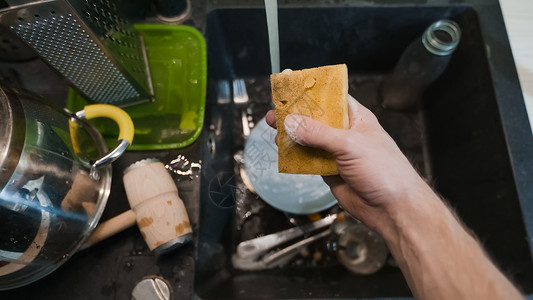 在黑水槽中洗脏餐具清洗剂消毒剂盘子黑色食物工作家务玻璃液体白色背景图片