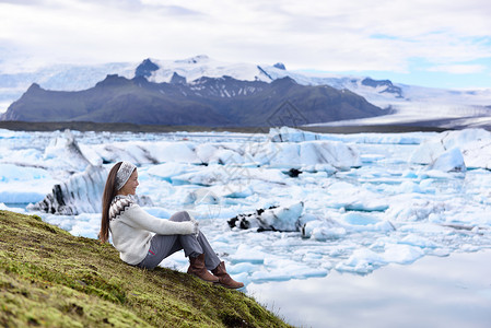 冰川泻湖冰岛观光游客享受Jokulsarlon冰川环礁湖 妇女访问目的地标志性冰川湖自然景观背景