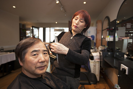 中国理发师的肖像 在美发店剪客户头发女性店铺剪发发型师剪刀商业工作微笑梳子职业造型师高清图片素材