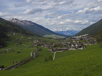 阿尔卑斯山俯图在奥地利因斯布鲁克附近的Stubaital或Stubai谷地与Neder村和 绿草原 雪覆盖山峰天空旅游溪流环境远足蓝色风景冰川背景