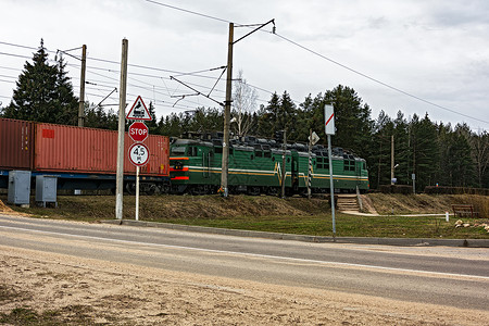 一辆货运火车的火车车正在穿越铁路交叉路口森林高清图片素材