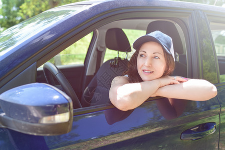 一个微笑着的女人的肖像 戴着帽子坐在车里 看一眼驾驶高清图片素材