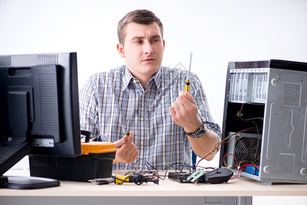 在车间修理计算机的年轻技工维修木板螺丝刀男人工作硬件处理器工具展示驾驶拆开高清图片素材