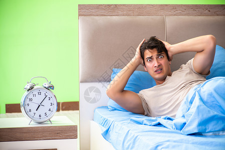 人睡眠有问题失眠时间压力闹钟男人警报头痛工作恶梦苏醒醒来高清图片素材