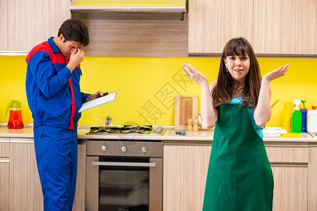 厨房有女承包商 在厨房讨论修理女士困惑安装说明男人家具工人木头修理工木工服务高清图片素材