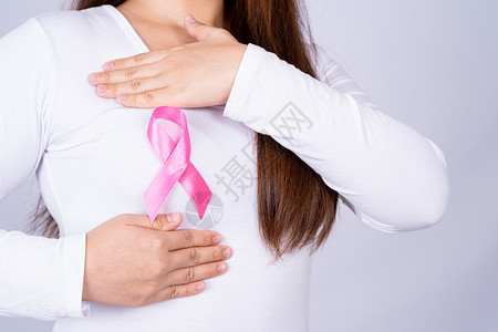 十月女孩女性胸部的乳腺癌意识丝带和灰色背景下的自我检查 广告概念的医疗 保健帮助女孩风险组织考试癌症活动治愈化疗丝绸背景