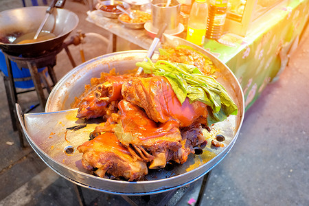 T区蒸锅街饭菜上的斜猪腿和蔬菜高清图片