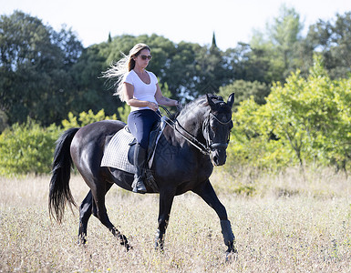 骑马的女童和女童动物骑术头盔运动黑色骑士训练闲暇活动女孩背景图片