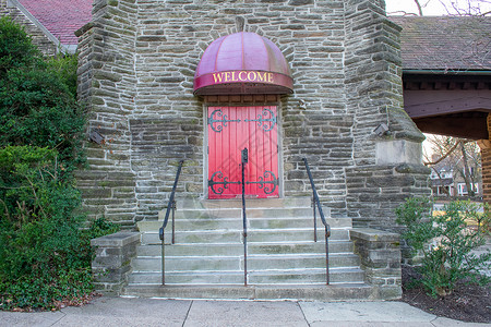 一个明亮的红门 在科布斯通墙壁上 挂着欢迎标志阿波夫背景图片