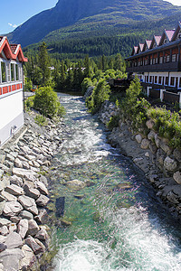 在挪威赫姆塞达两座房屋之间流淌着美丽的绿宝石河水背景图片