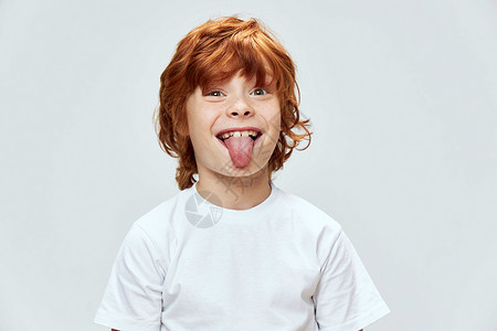 红头发男孩 展示白T恤滑稽的舌尖风景背景图片
