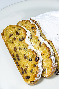 德文圣诞口哨白色面包蛋糕熟食盘子葡萄干烘烤诞蛋糕背景图片