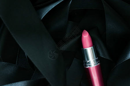 黑色丝绸背景的粉红口红 奢华化妆和美容皮革粉色光泽度静物魅力化妆品女士背景图片