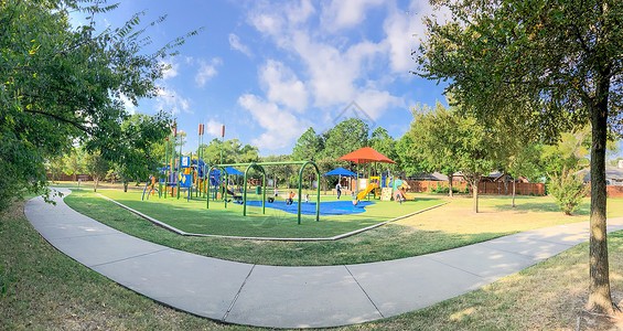全景全景 周围的游乐场 有太阳遮阳帆 在德克萨斯州美州Mound的花草蓝色闲暇孩子玩具人行道遮阳棚民众途径运动梯子背景图片