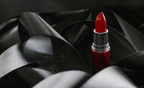 黑色丝绸背景的红口红 奢华化妆和美容女士化妆品皮革光泽度红色魅力静物背景图片
