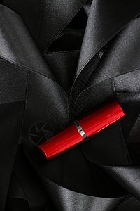 黑色丝绸背景的红口红 奢华化妆和美容静物皮革化妆品魅力红色女士光泽度背景图片