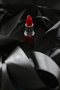 黑色丝绸背景的红口红 奢华化妆和美容化妆品魅力静物皮革女士红色光泽度背景图片