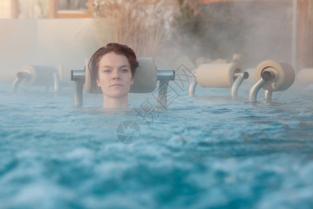 与一个年轻迷人的放松女性共创龙卷风酒店奢华温泉水池旅游洗澡身体比基尼运动皮肤背景图片