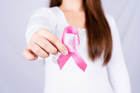 十月女孩女性胸前的乳癌认知带 灰色背景 医疗 保健 宣传概念 在卫生方面治疗机构幸存者帮助外科治愈风险药品癌症女孩背景