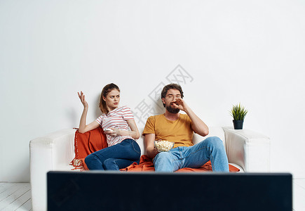 看着电视看已婚夫妇在沙发上与已婚夫妇结婚的男女 一朵花在锅里乐趣视频家庭展示控制享受电影长椅成人技术背景图片