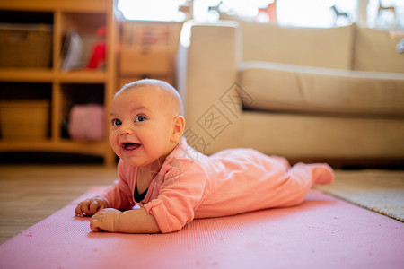 小贝鲁表情微笑的女婴躺在粉红鲁上手势表情俯卧肌肉小地毯女儿乐趣房间内饰姐妹背景