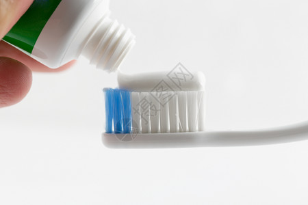 手按牙刷上的牙膏斑点身体洗涤药品化妆品牙科科学卫生牙齿家庭背景图片