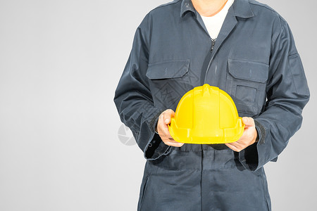 站在蓝色封面内站着的贴近工作员工作服制造业工作员工工人工程师男人技术员建筑师帽子背景图片