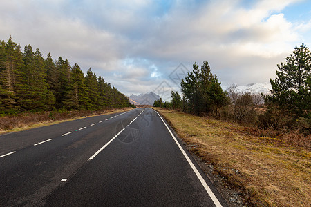 苏格兰森林路孤独的孤单路在天空中的白山沙丘兰背景