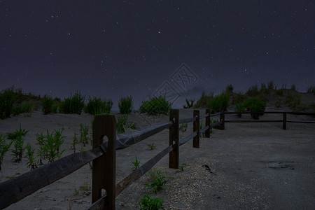 海滩路和街边有栅栏和夜空的圣光背景图片