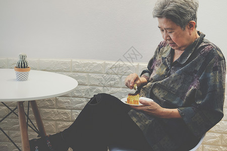 在餐厅吃芝士蛋糕的年老老年妇女 成熟退休生活方式在晚宴上享受食物女性午餐老人女士美食祖母甜点甜的高清图片素材