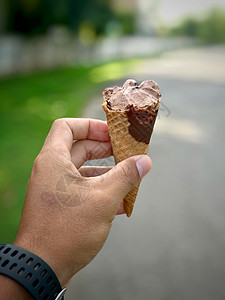 手握冰淇淋 不集中自然背景 夏日背景图片