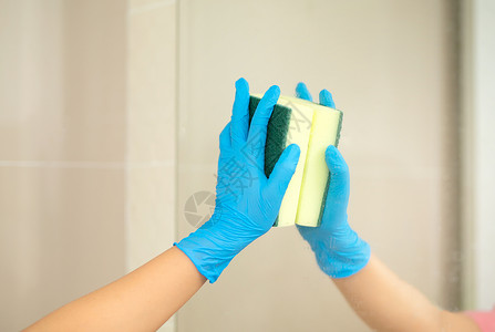 海绵池近身妇女手持蓝色橡胶手套 在照片中打扫海绵 搬走洗浴池和镜子洗涤剂感染保健洗澡清洗剂洗手间家务家政细菌浴室背景