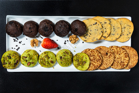 黑背景 顶视图上色的美味多彩巧克力饼干坚果高清图片素材
