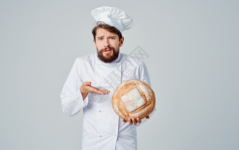 穿轻便衣服的厨师 手握着圆环面包饼 他以它为代言人背景图片