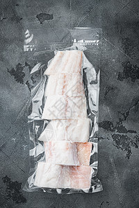 鱼包Haddock鱼在真空袋中无皮肤 灰色背景 最高视野小袋白色真空塑料包装白鱼密封海鲜鳕鱼市场背景