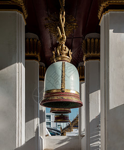 寺庙钟声素材古代钟声挂在泰神庙外的柱子上文化艺术金属金子古钟宗教寺庙雕像黄铜寺钟背景